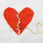 cross stitched heart torn in two stiched together with golden thread for betrayal trauma from sex addiction